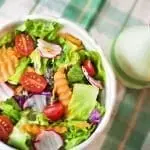 garden salad in bowl with vinegrette cruette